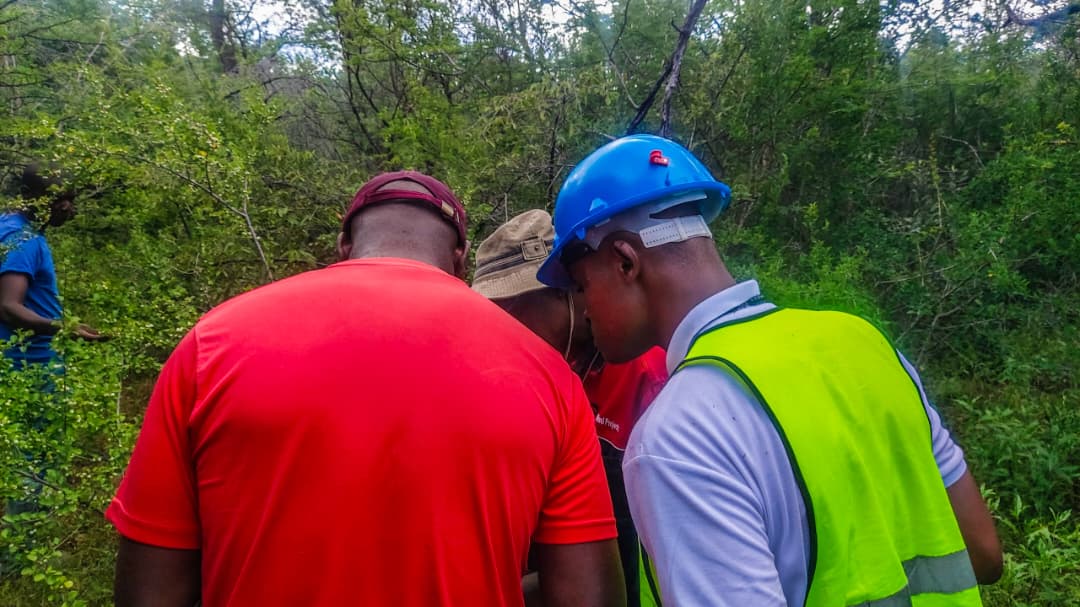 Surveying team reviewing the Bushu Claims site in protective field equipment