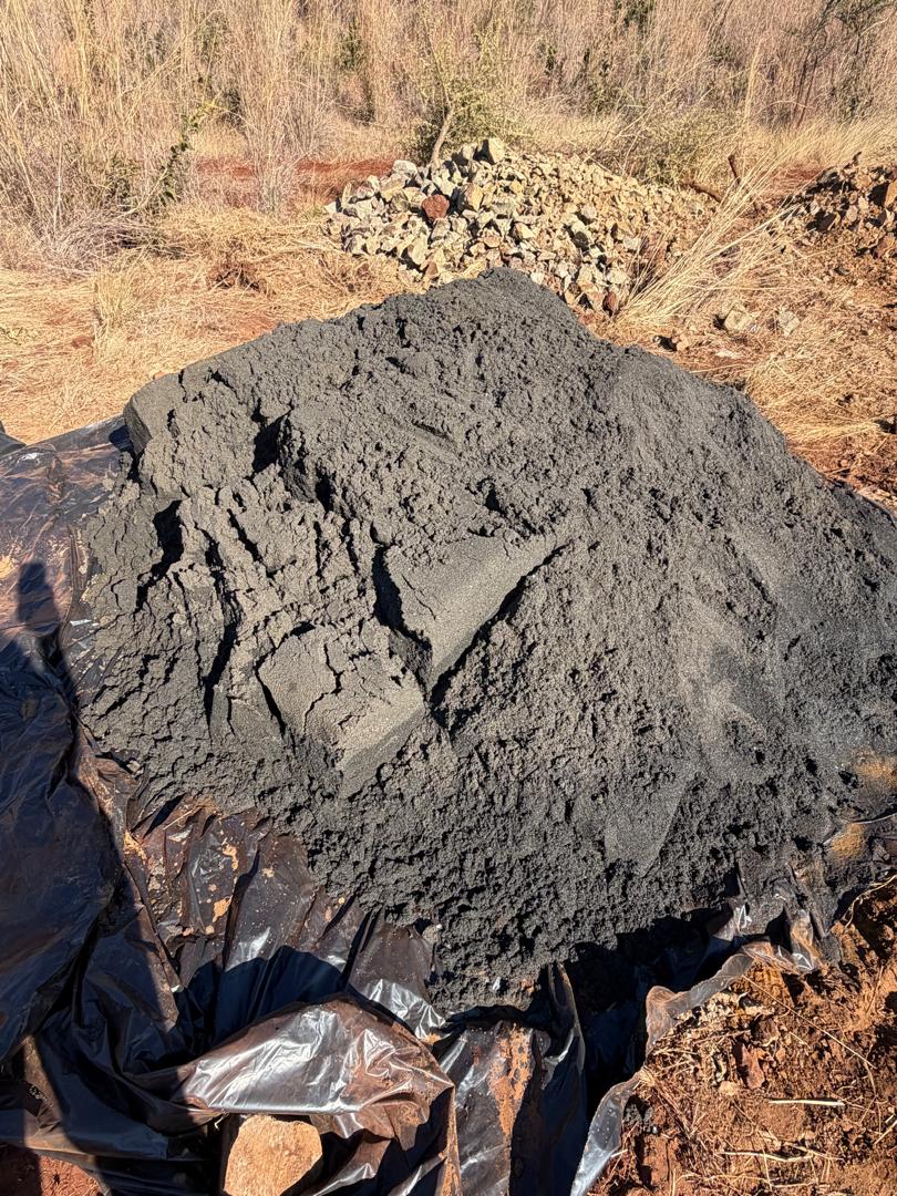 Close-up view of dark recovered alluvial chrome material on ground sheeting
